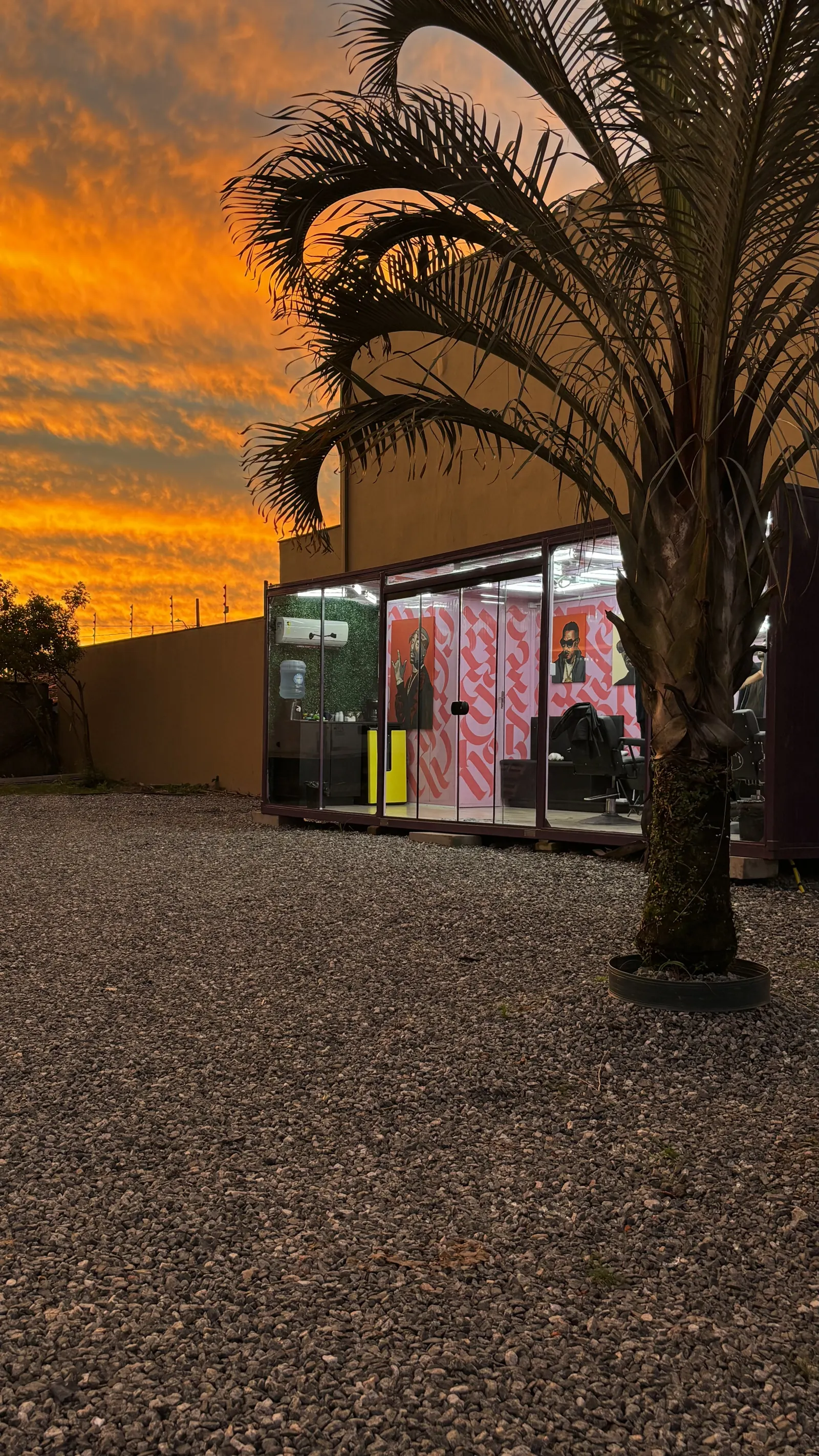 Studio AG Barber ao pôr do sol, com o céu laranja refletindo no container de vidro